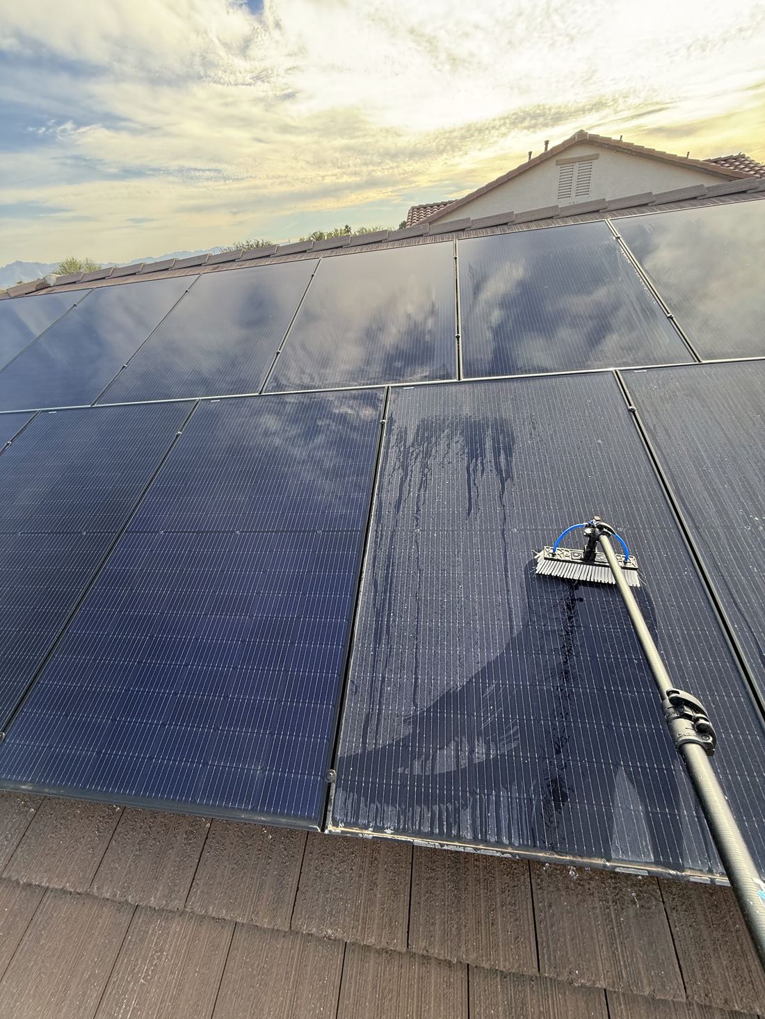 Solar panels being cleaned at sunset by Apex Power Washing